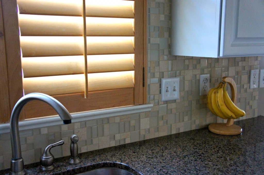 glass and tile back splash up and around the sink is so pretty and seamless!