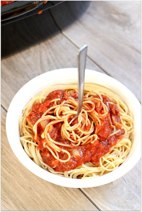 Don't buy cans or jars spaghetti sauce at the grocery store...make it at home! Make it at home in your slow cooker. It's super easy and tastes amazing after simmering all day long. Make a huge batch and freeze the leftovers for an easy dinner another night.