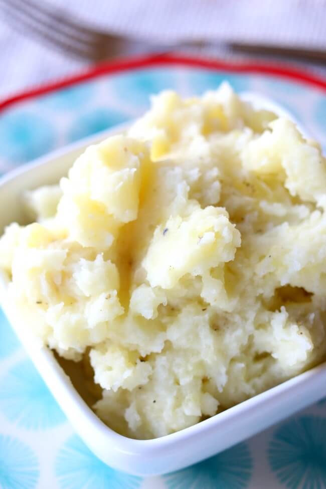 Slow Cooker Buttermilk Mashed Potatoes--these are my favorite mashed potatoes. Cubed potatoes are cooked for a few hours in your slow cooker with garlic cloves and bay leaf. Then they're mashed with butter and buttermilk for ultimate creaminess and flavor. 