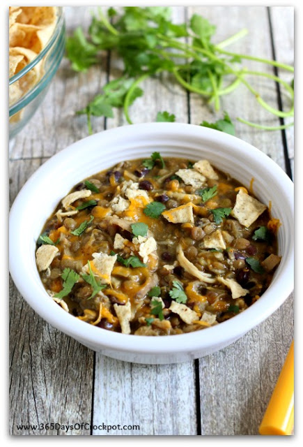 Instant Pot Cheesy Chicken and Lentils--lentils and chicken are pressure cooked with green salsa and black beans to make a creamy one pot dinner. Top it with cheddar, sour cream, cilantro and crunched up tortilla chips for the ultimate Mexican meal.