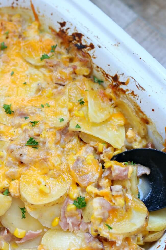 Slow Cooker Cheesy Scalloped Potato Casserole--thinly sliced yellow potatoes, cubed ham and juicy sweet corn enveloped in a velvety cheese sauce and baked all day in your slow cooker. 