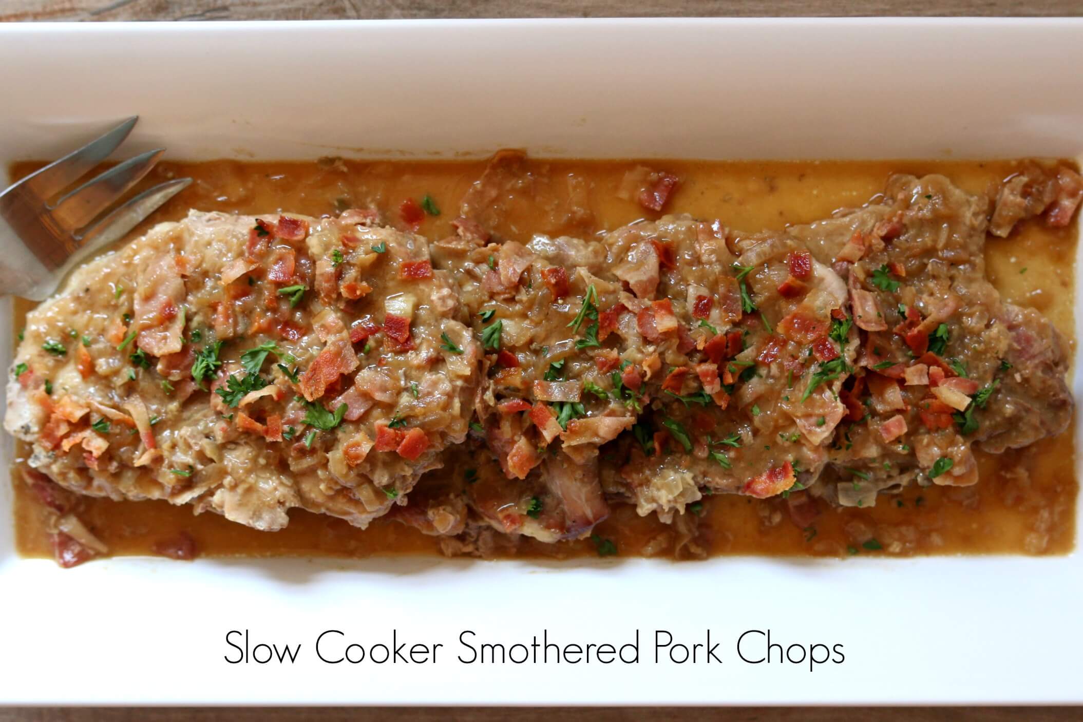 Slow Cooker Smothered Pork Chops with Bacon--the best slow cooker pork chops recipe ever! Tender pork smothered with savory sauce and bacon crumbles all made in your slow cooker. 