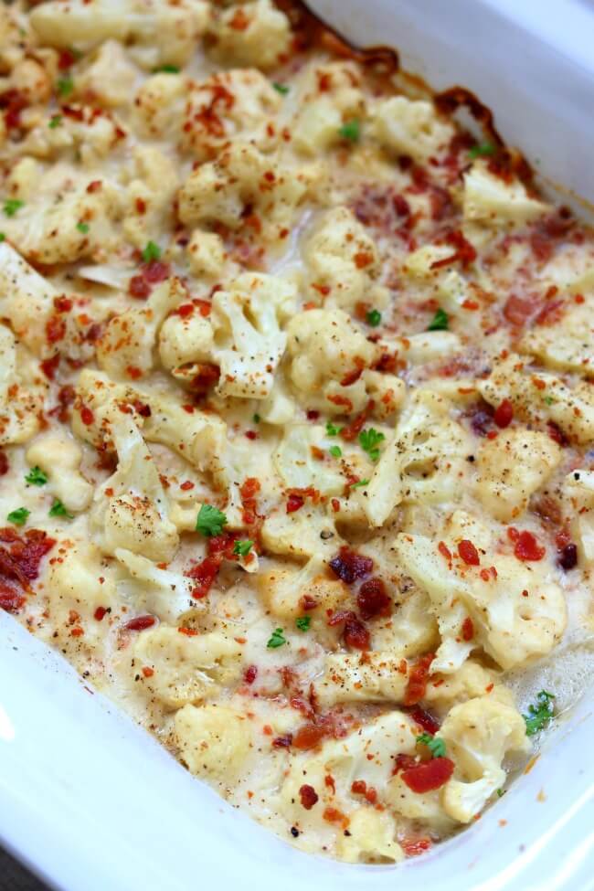 Slow Cooker Cheesy Bacon Cauliflower--a slow cooker cauliflower side dish that is enveloped in a velvety mozzarella cheese sauce and topped with crispy, crumbled bacon.