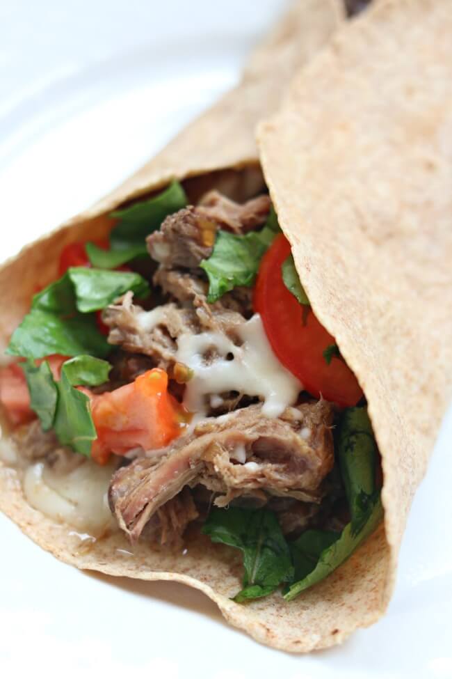 Slow Cooker French Dip Tacos--tender, moist shredded roast beef rolled up in a soft flour tortilla and topped with melty mozzarella cheese. Dip it in au jus sauce for best results!