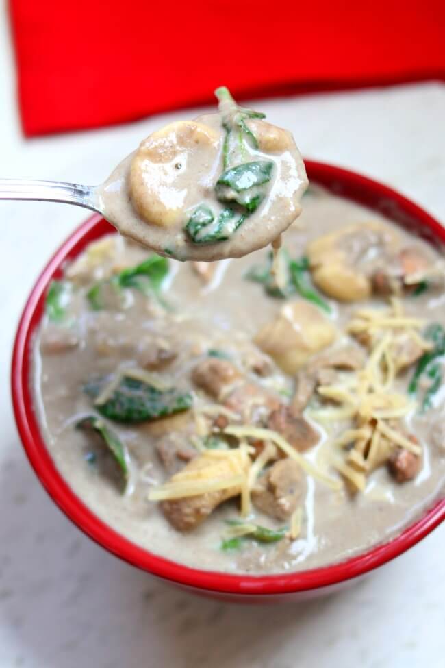 Slow Cooker Chicken Mushroom Tortellini Soup: a creamy, comforting cream of mushroom soup with tender bites of chicken, cheesy tortellini, fresh spinach and topped with freshly grated Parmesan cheese. 