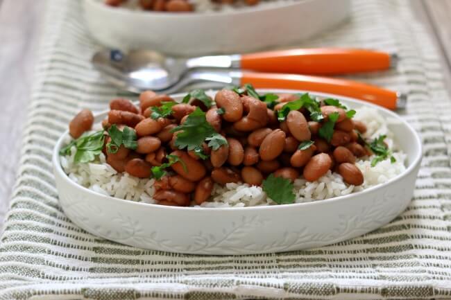 Dave Ramsey Slow Cooker Beans and Rice Recipe--if you're trying to cut down on your grocery bill I have a nourishing and inexpensive slow cooker beans recipe. We start with dried pinto beans (cheap!) and cook them all day while you're at work (earning money to pay off your debts). Add in some salt, cumin, garlic powder and tomato sauce and you have dinner (or lunch)!
