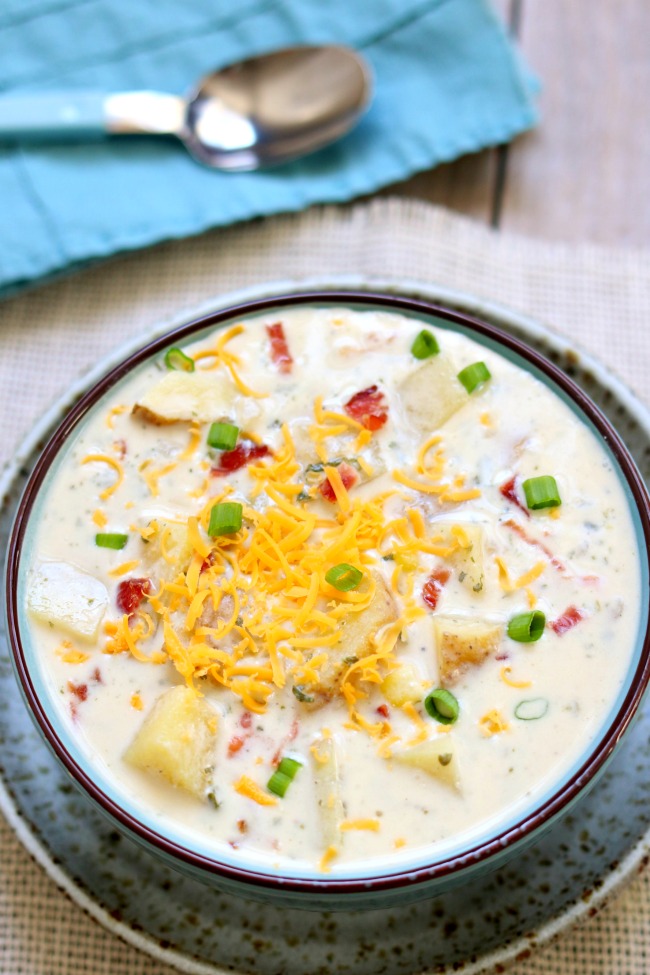 Slow Cooker Sour Cream Potato Bacon Soup--this crockpot soup has a creamy broth, juicy corn kernels, crispy bacon, grated cheddar, tangy cream cheese and sour cream and mild green onions. It is comfort in a bowl and is an easy dinner recipe that takes just minutes to put together. 