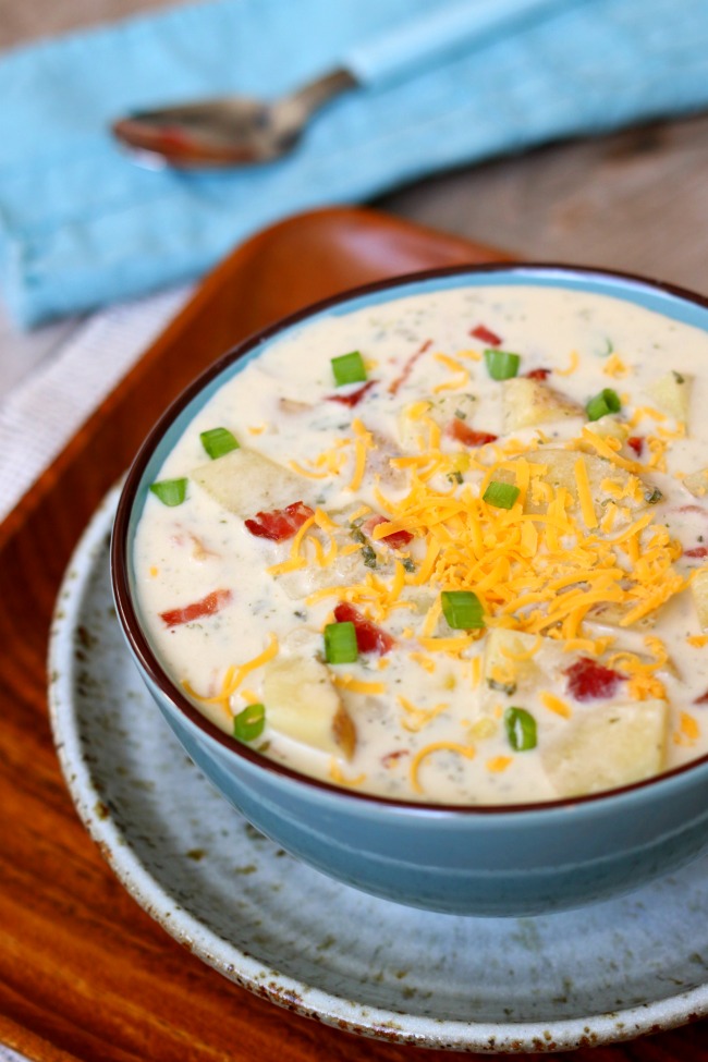 Slow Cooker Sour Cream Potato Bacon Soup--this crockpot soup has a creamy broth, juicy corn kernels, crispy bacon, grated cheddar, tangy cream cheese and sour cream and mild green onions. It is comfort in a bowl and is an easy dinner recipe that takes just minutes to put together. 