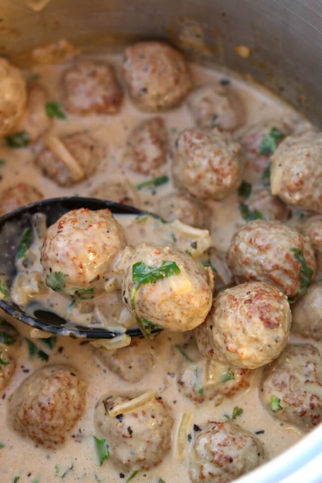Slow Cooker Spicy Coconut Meatballs--a slightly spicy creamy coconut sauce that is simmered with flavorful meatballs and then topped with chopped cilantro. This is such an easy recipe but totally tastes like something you'd order at a restaurant.