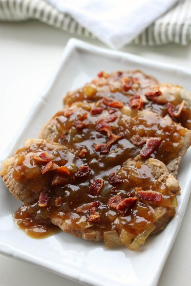 Instant Pot Smothered Pork Chops--thin sirloin pork chops cooked in the pressure cooker until tender and topped with a savory sauce and bacon crumbles.
