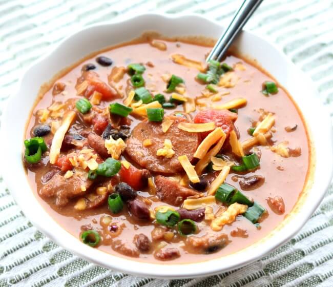 Instant Pot (or Crockpot) Sausage and Bacon Chili Soup--a mix of dried kidney, pinto and black beans cooked in your pressure cooker with onion and chili seasonings. Then a generous amount of sliced sausage and crispy, crumbled bacon and sour cream are added to make it a creamy and comforting soup that you won't be able to resist. 