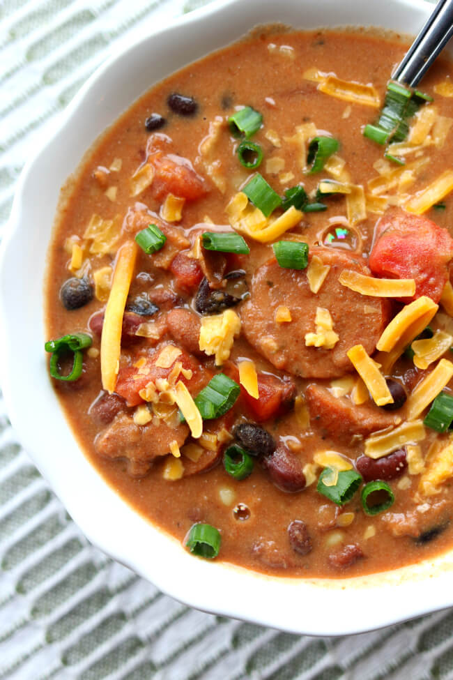 Instant Pot (or Crockpot) Sausage and Bacon Chili Soup--a mix of dried kidney, pinto and black beans cooked in your pressure cooker with onion and chili seasonings. Then a generous amount of sliced sausage and crispy, crumbled bacon and sour cream are added to make it a creamy and comforting soup that you won't be able to resist. 