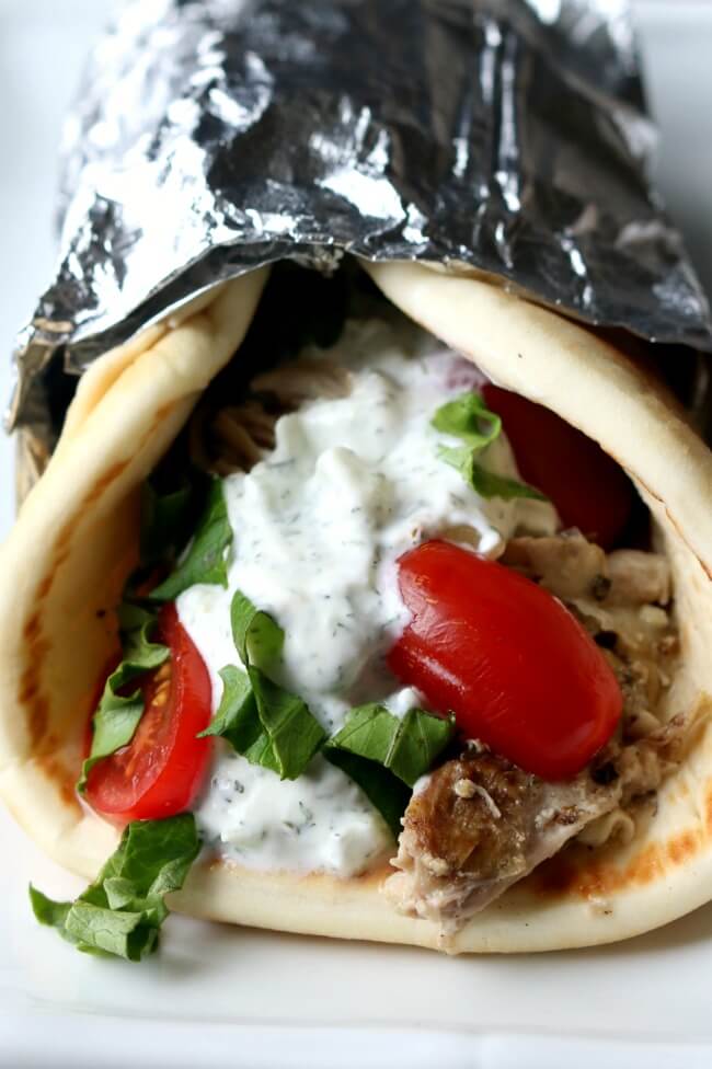 Instant Pot Chicken Gyros--tender, juicy seasoned chicken and onions piled onto soft pita bread and topped with a creamy cucumber yogurt sauce, tomatoes and lettuce. A perfect meal for any night of the week.