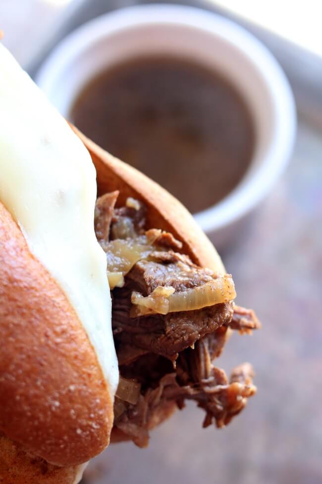The French dip sandwich is a hot beef sandwich consisting of tender thin slices of beef layered a long white French roll that is dipped into a flavorful sauce made from the pan juices. It is a staple at any diner in America. My recipe is a mash-up between French Onion Soup and the French Dip Sandwich. Caramelized onions are piled along with the beef and cheese on a crusty roll.