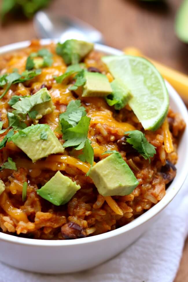 Instant Pot Cheesy Enchilada Rice–brown rice is pressure cooked with enchilada sauce and spices in minutes and then topped with sharp cheddar, diced avocado and a wedge of lime. 