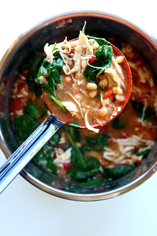 Instant Pot Chicken White Bean Spinach Soup--a healthy and easy recipe for any night of the week. Shredded white meat chicken is enveloped in a flavorful broth and surrounded by seasoned white beans, petite diced tomatoes and fresh spinach.