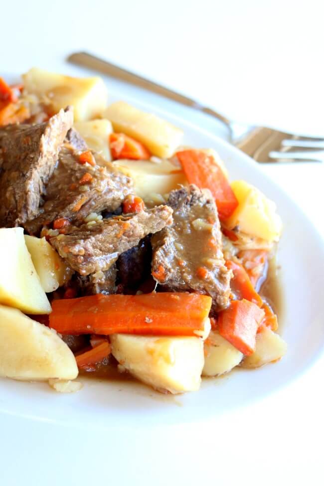 Instant Pot 5-Ingredient Pot Roast Dinner--a chuck roast is cooked until moist and tender in an hour in your Instant Pot (mine was frozen!) along with seasoned vegetables. The meal is finished off with homemade gravy. 