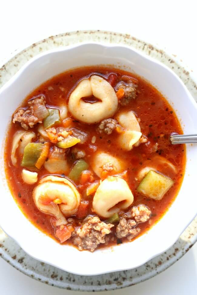 Slow Cooker Italian Tortellini Soup--Italian sausage is browned with onions and garlic and then beef broth, tortellini, tomatoes, green peppers and zucchini are simmered together to produce a soup with ultimate flavor.