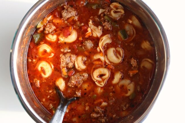Slow Cooker Italian Tortellini Soup--Italian sausage is browned with onions and garlic and then beef broth, tortellini, tomatoes, green peppers and zucchini are simmered together to produce a soup with ultimate flavor.  