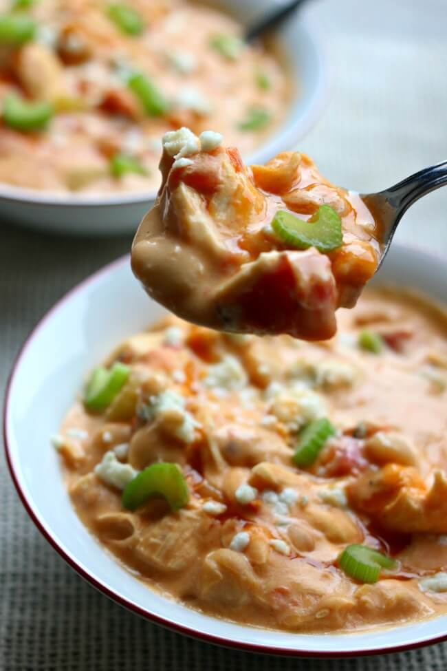 Slow Cooker Buffalo Chicken Chili--a creamy white bean chicken chili that is flavored with buffalo sauce and fire roasted tomatoes. It's basically the soup version of buffalo chicken dip. 