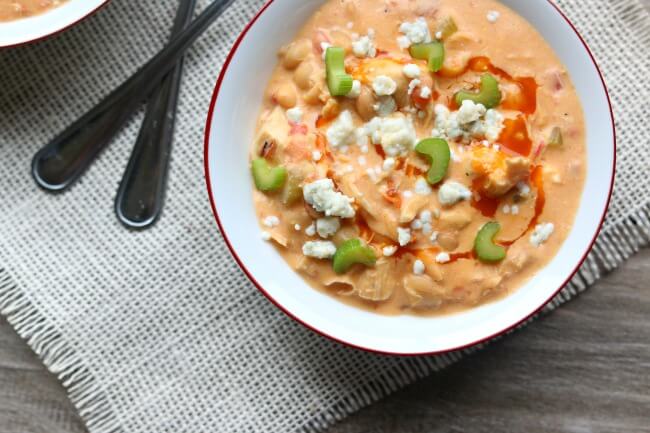 Slow Cooker Buffalo Chicken Chili--a creamy white bean chicken chili that is flavored with buffalo sauce and fire roasted tomatoes. It's basically the soup version of buffalo chicken dip.