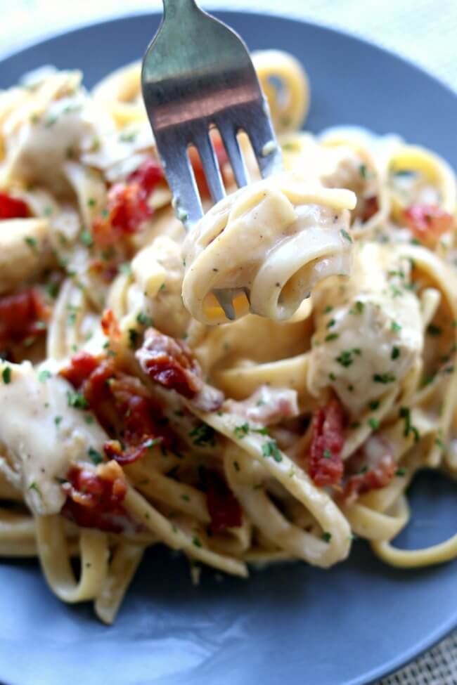 Instant Pot Bacon Chicken Fettuccine Alfredo--a creamy sauce envelopes pasta and tender bites of chicken. Crumbled bacon finishes the dish off and adds extra flavor. This chicken alfredo is all made in one pot cutting down on time and dishes to clean. 