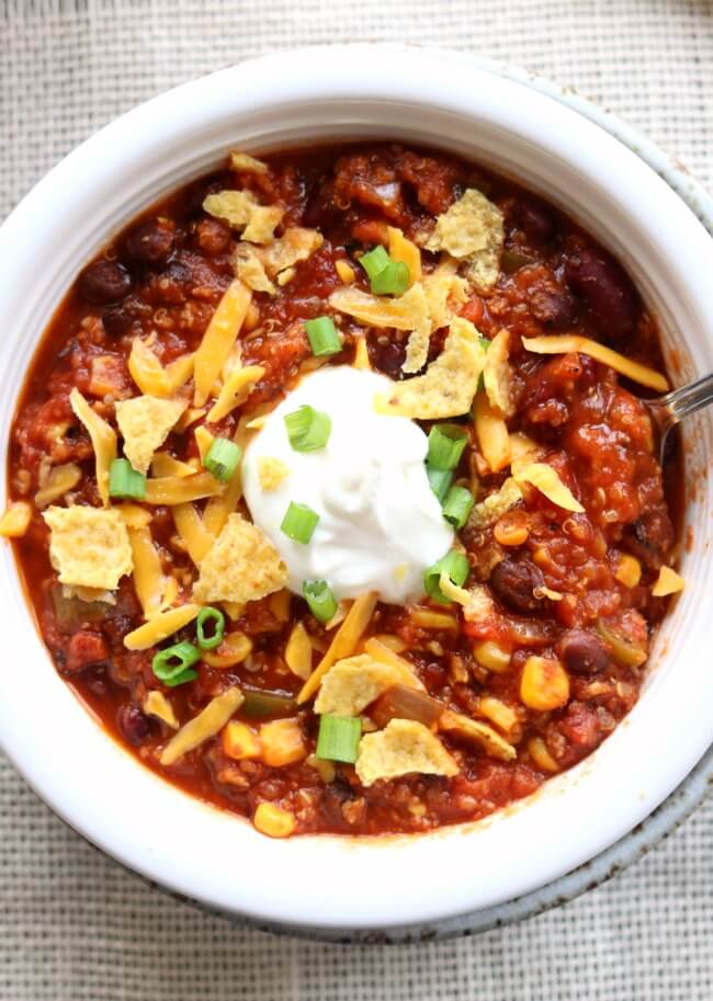 Slow Cooker Turkey Chili--ground turkey is simmered with fire roasted tomatoes, green pepper, onions, garlic, beans and spices to produce a comforting bowl of chili that is topped with cheese, fritos and green onions. (P.S. you can also use ground beef in this recipe)