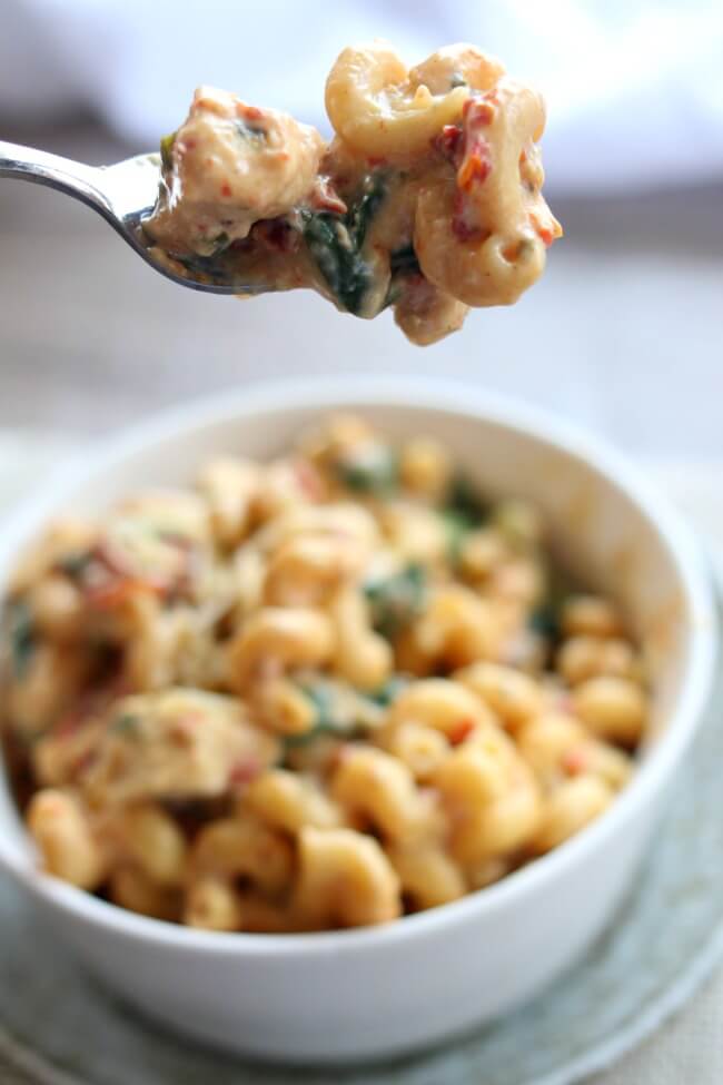 Instant Pot Tuscan Chicken Pasta--curly pasta is enveloped in a creamy parmesan, basil and cream cheese sauce with bites of sun-dried tomatoes, spinach and tender chunks of chicken. 