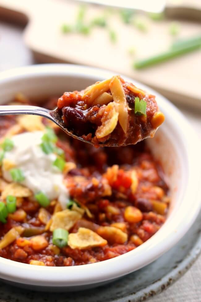 Instant Pot Turkey Chili--ground turkey is simmered with fire roasted tomatoes, green pepper, onions, garlic, beans and spices to produce a comforting bowl of chili that is topped with cheese, fritos and green onions. (P.S. you can also use ground beef in this recipe)
