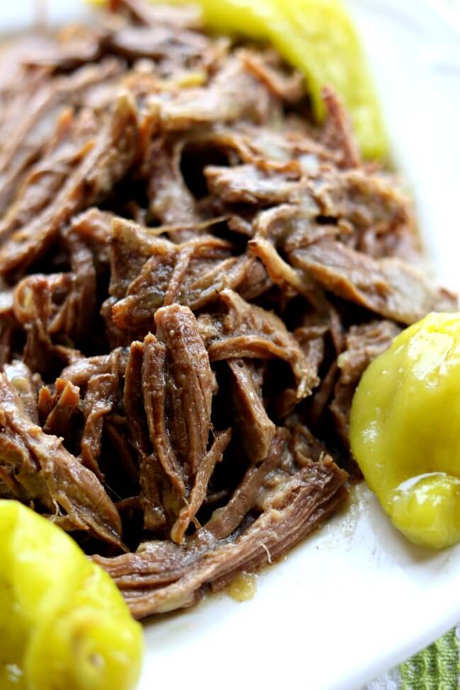 Slow Cooker Mississippi Roast (no packets)--with just a handful of ingredients and your trusty crockpot you can make the best roast of your life. This particular recipe has no packets of ranch or au jus like the original recipe calls for.  The meat is slightly spicy and infused with flavor. This roast is perfect served with mashed potatoes or on a crusty roll as a sandwich. 