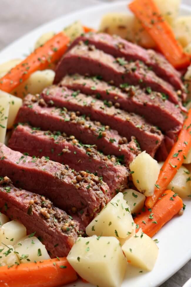Instant Pot Corned Beef Dinner with Mustard Sauce--a super easy (and delicious) method for making corned beef! Tender corned beef is sliced and served alongside carrots and potatoes (and if you want, cabbage). Top your corned beef with a tangy sauce made of sour cream, dijon mustard and garlic. A perfect dinner for St Patrick's Day (or any other day). 