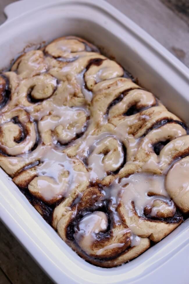 Slow Cooker Cinnamon Rolls--gooey yeast bread cinnamon rolls made easy in the slow cooker. Because they are cooked slowly you don't have to let the cinnamon roll dough raise! Cut out the step of raising the dough twice and just let the cinnamon rolls raise and cook at the same time in the slow cooker. 
