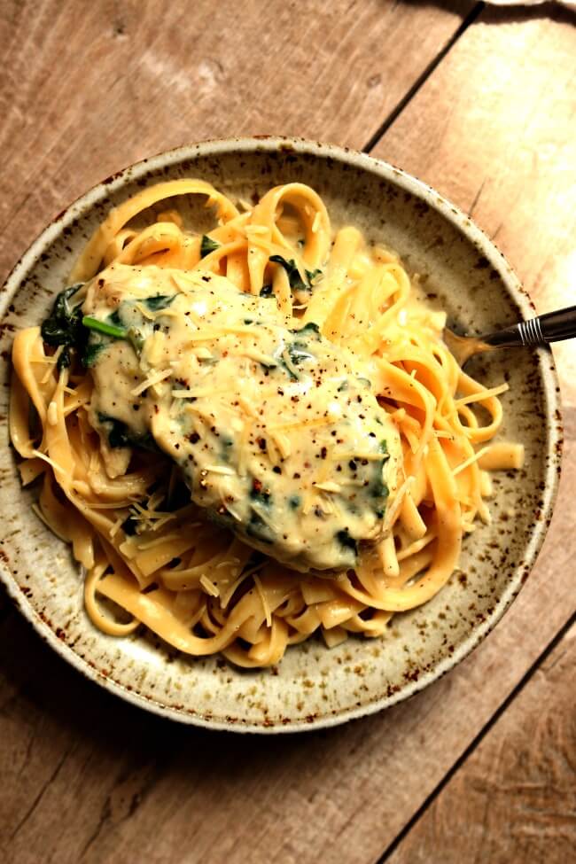 Instant Pot Garlic Parmesan Chicken--a fast and easy chicken dinner with a creamy garlic parmesan sauce with chopped spinach. We like to eat this chicken and sauce with fettuccine noodles or with mashed potatoes. 