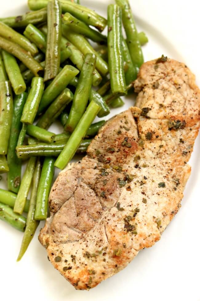 Slow Cooker Garlic Herb Pork Chops and Green Beans--slow cooked pork chops and green beans are full of rich buttery herb flavors. Serve as is for a low-carb meal or serve with your favorite starch (potatoes, rice or noodles). 