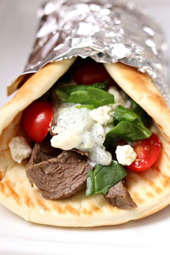 Instant Pot Steak Gyros--tender, seasoned pieces of steak rolled up in a soft pita with tzatziki sauce, tomatoes, onions, lettuce and feta cheese. An easy meal that tastes amazing any night of the week! 