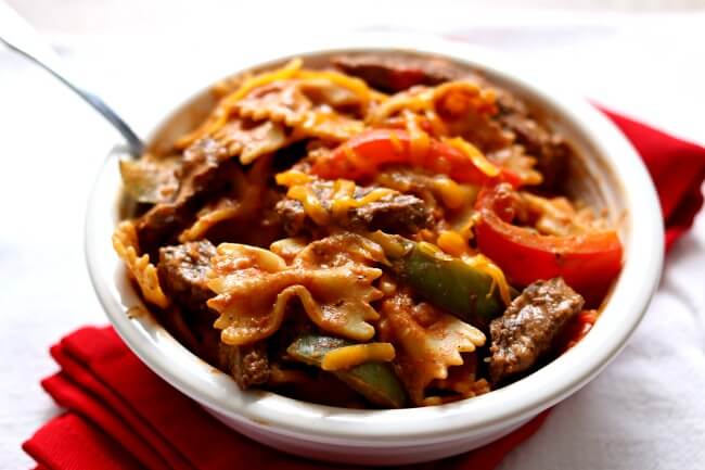 Instant Pot Steak Fajita Pasta--all the delicious flavors of fajitas in a pasta dish! Steak is cooked with fajita seasonings, pasta and tender, but not overcooked, bell peppers. Sour cream is stirred in to add a creamy element to the pasta dish and ties everything together. Make this recipe is just minutes with your electric pressure cooker.