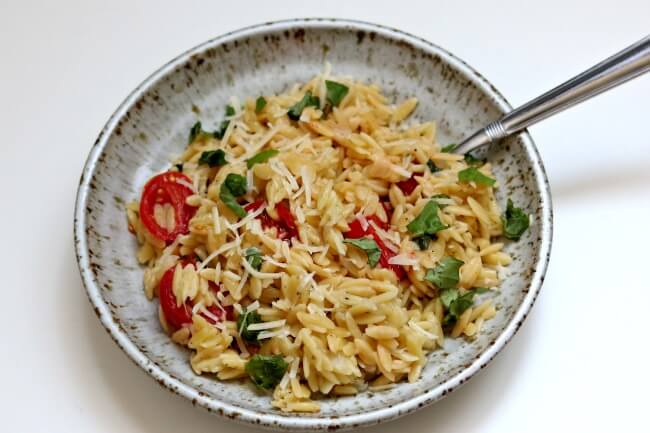 Instant Pot Tomato Basil Parmesan Orzo--orzo pasta is tossed with fresh basil, garlic, halved cherry tomatoes and parmesan cheese for a perfect side dish or meatless meal. 