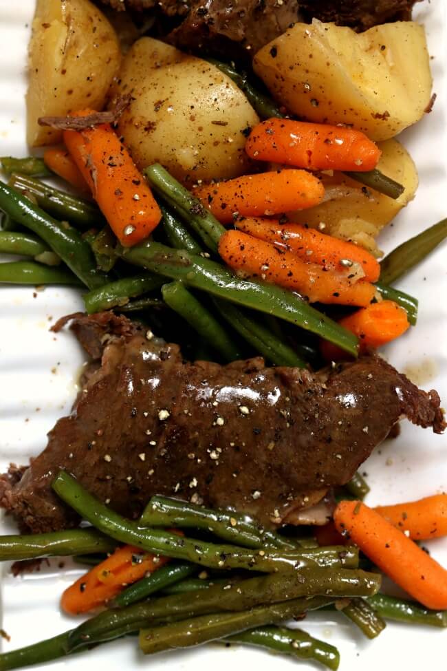 Slow Cooker Grandma's Sunday Roast--get fall apart roast paired with potatoes, carrots, green beans and gravy made easy in your slow cooker. A perfect Sunday dinner just like Grandma used to make. 