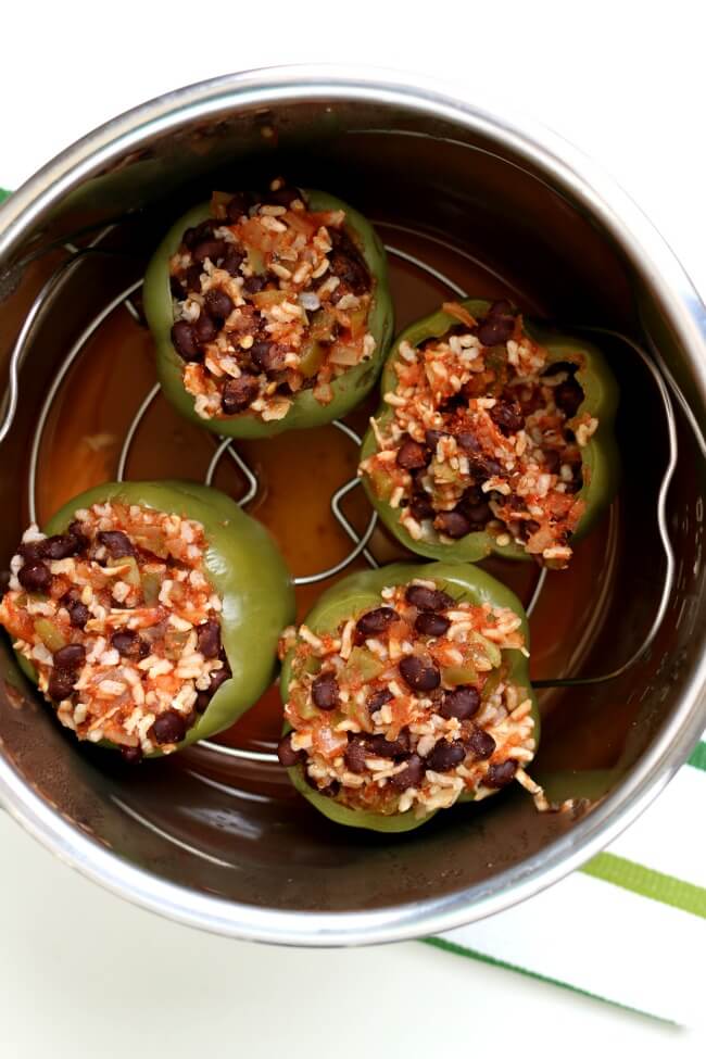 Instant Pot/Slow Cooker Mexican Stuffed Peppers--bell peppers are stuffed with brown rice, black beans and salsa and cooked perfectly in your electric pressure cooker or your crockpot. You can make them vegetarian or with meat, it's up to you. Top with a dollop of sour cream and enjoy this healthy weeknight dinner. 