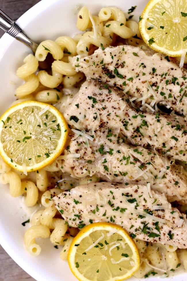 Slow Cooker Creamy Lemon Parmesan Chicken--tender bites of chicken enveloped in a creamy parmesan and lemon sauce. Serve the chicken and sauce with pasta, rice or even zoodles. 