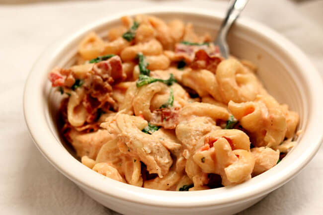 Instant Pot Chicken Bacon Ranch Pasta--curly pasta is enveloped in a creamy sauce with tender bites of chicken, crispy bites of bacon and a green pop of color from spinach or broccoli. A one pot pasta dish that rivals anything you can order at a restaurant. 