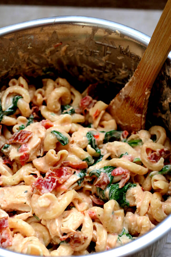 Instant Pot Chicken Bacon Ranch Pasta--curly pasta is enveloped in a creamy sauce with tender bites of chicken, crispy bites of bacon and a green pop of color from spinach or broccoli. A one pot pasta dish that rivals anything you can order at a restaurant. 