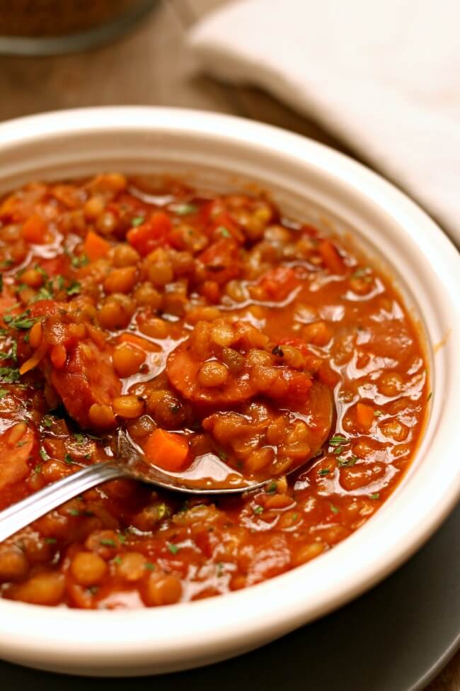 Slow Cooker Lentil Stew--a comforting bowl of stew that can be make vegan or can be made with smoked sausage. Lentils simmer in the slow cooker all day and soak up all the flavors of the stew. The leftovers make a great lunch the next day too.
