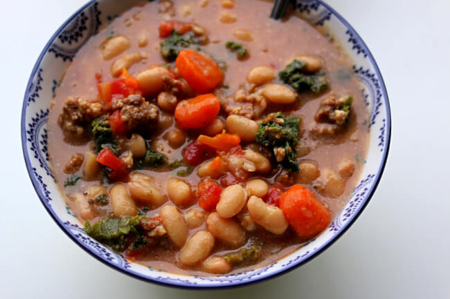 Instant Pot Tuscan Sausage White Bean Soup--dried white beans are quickly pressure cooked and make an amazing soup with Italian sausage, carrots, tomatoes, kale and parmesan cheese. The flavor is unbelievably good! This soup is naturally gluten free. 