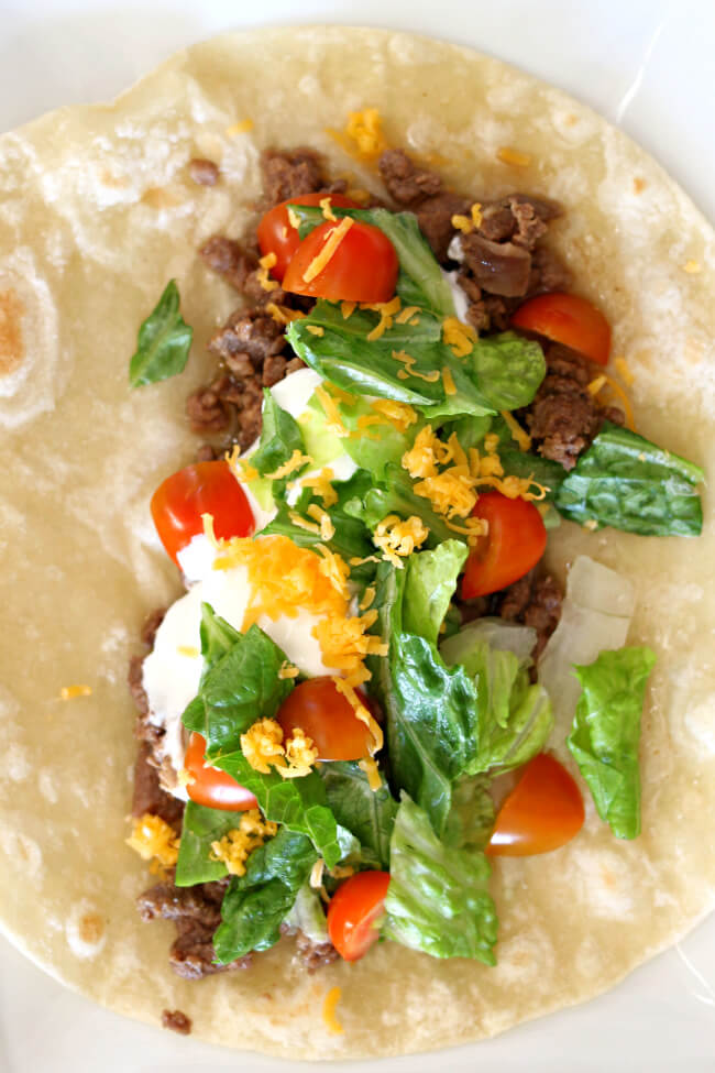 Slow Cooker Carne Asada Street Tacos--an easy way to make carne asada! Throw everything into the crockpot and walk away. Serve the meat over small fresh soft flour tortillas and top with your favorite taco toppings.