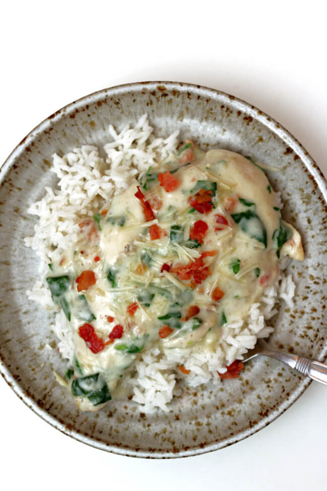 Instant Pot Garlic Parmesan Bacon Chicken--a creamy sauce and chicken with parmesan cheese, bacon, garlic and spinach. Make pot-in-pot rice at the same time to serve with the chicken and sauce. 