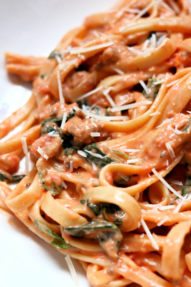 Instant Pot Creamy Tomato Parmesan Fettuccine--a big bowl of noodles with a creamy tomato sauce, spinach, Italian sausage and parmesan cheese. ﻿