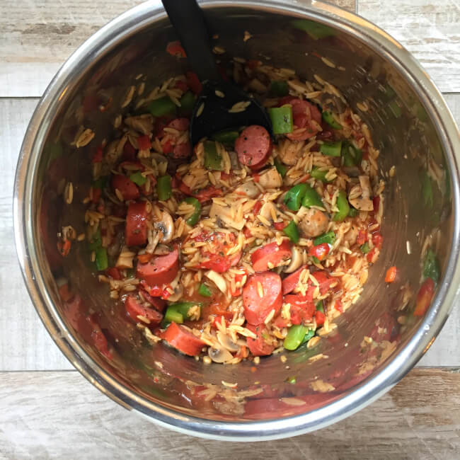 Instant Pot Smoked Sausage with Parmesan and Orzo--smoked sausage, peppers, mushrooms, tomatoes, orzo and parmesan cheese cooked quickly in your pressure cooker. This meal is loaded with flavor and is a dump and go one pot meal. 