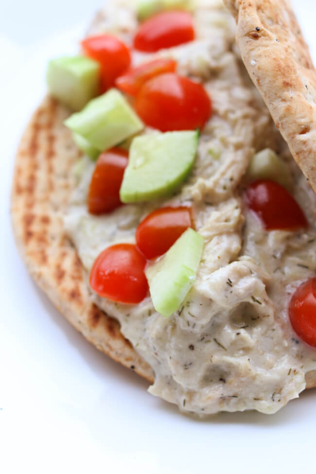 Instant Pot Creamy Dill Chicken--chicken with garlic, lemon pepper, dill, and lemon juice encoated in creamy yogurt and then wrapped in a warm pita with diced cucumbers and cherry tomatoes. A perfect summer meal!