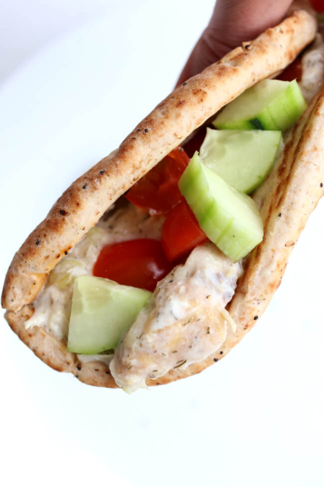 Instant Pot Creamy Dill Chicken--chicken with garlic, lemon pepper, dill, and lemon juice encoated in creamy yogurt and then wrapped in a warm pita with diced cucumbers and cherry tomatoes. A perfect summer meal!